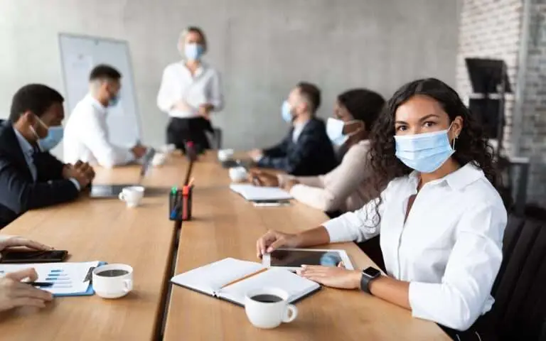 Businesswoman In Face Mask Sitting Attending Corporate Meeting In Office